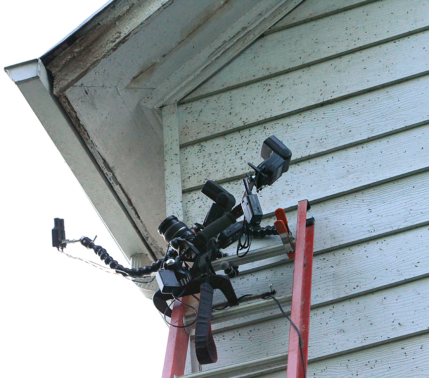 camera setup on C-clamp secured to extension ladder